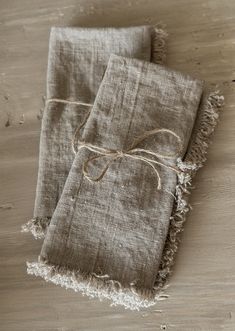 two linen napkins tied together on a wooden table