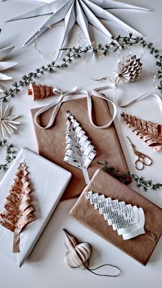 several different types of crafting supplies are laid out on a white surface with greenery around them