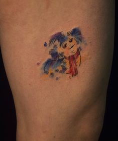 a small tattoo on the side of a woman's thigh shows a dog with a scarf around its neck