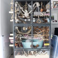 a bird cage filled with lots of birds in it's storage area next to a refrigerator