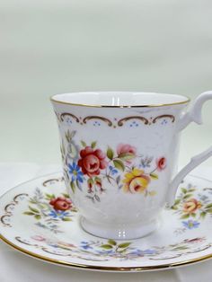 a cup and saucer sitting on top of a white table