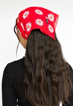 a woman with long brown hair wearing a red flowered bandana on her head