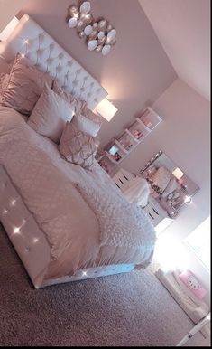 a large bed sitting in a bedroom next to a wall with lights on top of it