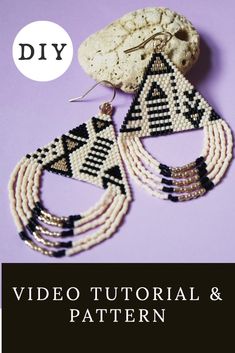 a pair of beaded earrings sitting on top of a purple table next to a rock