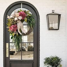 the front door is decorated with wreaths and flowers