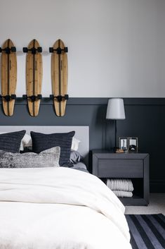 two surfboards mounted to the wall above a bed