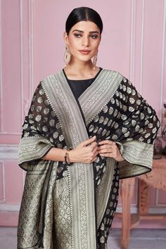 Beautiful black Banarasi saree with silver zari buta and border is a perfect choice for festive occasions. It comes with a matching blouse piece. Disclaimer: The shown stitched blouse on the model is for display purpose only. The saree comes with a matching blouse piece and finished with fall and piko. Black Saree With Silver Border, Black Banarasi Saree, Black Banarasi Silk Pre-draped Bollywood Saree, Luxury Black Saree With Printed Border, Black Saree With Golden Border, Black Saree With Printed Border Unstitched, Banarasi Sari, Latest Designer Sarees, Banarasi Saree