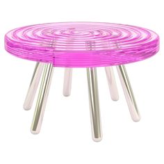 a pink table with three metal legs and four different colored circles on the top,