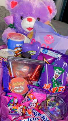 a purple teddy bear sitting on top of a pile of candy