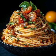 pasta with tomatoes and basil in a black bowl