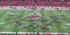 a marching band is on the field in front of an audience at a football game