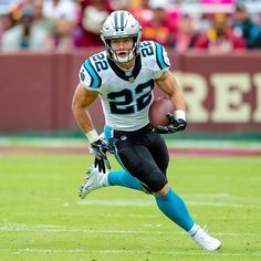 a football player running with the ball in his hand and people watching from the stands