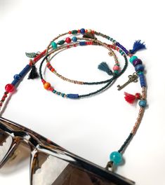 Unisex Bohemian Glasses Chain,Handmade Ethnic Sunglasses Cord,Key Charm Beaded Eye Glass Holder,Tussel Mask Chain,Gift for Her,Long Necklace If you are tired of playing hide and seek with your glasses and masks, there is a colorful news for you! Thanks to our handmade eyeglass straps, which make it almost impossible to lose glasses and give life to boring frames, you can wear your glasses comfortably by hanging them on your neck when not wearing them. It completes your full BOHO chic look! You c Bohemian Gold Glasses Chains With Colorful Beads, Adjustable Summer Jewelry With Tassels, Adjustable Tassel Jewelry For The Beach, Adjustable Tassel Jewelry For Beach, Bohemian Gold Beaded Glasses Chains, Bohemian Blue Beaded Glasses Chains, Adjustable Multicolor Glasses Chains For Festivals, Bohemian Glasses Chains With Adjustable Chain As Gift, Festival Beaded Glasses Chains With Round Beads