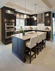 a kitchen with black cabinets and white counter tops