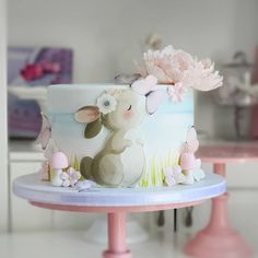 there is a cake decorated with flowers and animals on the top of this cake stand