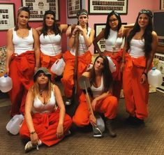 a group of women in orange outfits posing for a photo