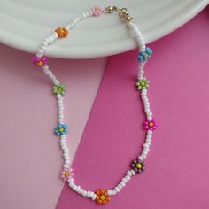 a white beaded necklace with flowers on it