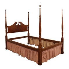 a wooden bed with four posts and pink bedspread