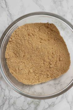 a bowl filled with dry ingredients on top of a marble counter