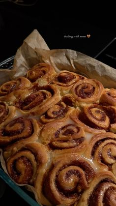 cinnamon rolls in a glass baking dish on top of a stove