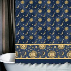 a bath tub sitting next to a shower curtain with sun and moon designs on it