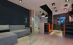 a living room filled with furniture next to a kitchen