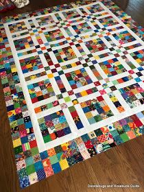 a very large quilt on the floor with lots of different colors and shapes in it