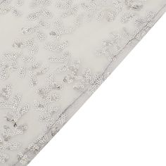 an image of the bottom of a mattress with white flowers and beads on it's side