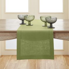 the table is set with three glass bowls and a place mat on it, along with two empty dishes