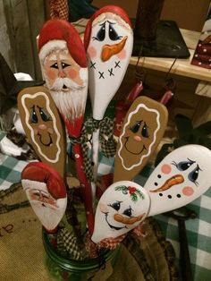 a bunch of spoons that are sitting in a vase with santa claus and snowmen on them