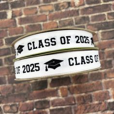 two white graduation ribbon on a brick wall