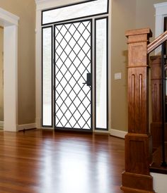 an empty room with wood floors and glass doors