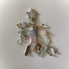 a key chain with charms attached to it on a white surface, featuring an image of a woman