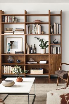 a living room filled with lots of bookshelves next to a couch and coffee table