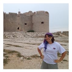 a woman standing in front of an old castle