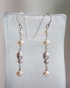 These pearl earrings can even make your parka look classy. Made with a mixture of white and silvery peacock freshwater pearls, I've connected them via wire wrapping and finished them off with sterling silver ear wires. To the lucky buyer of these earrings: Wear them well and often! Silver Dangle Linear Earrings With Pearl Drop, Silver Pearl Earrings With Ear Wire, Silver Sterling Pearl Drop Linear Earrings, Silver Linear Earrings With Pearl Drop For Anniversary, Silver Teardrop Wire Wrapped Pearl Earrings, Elegant Silver Wire Wrapped Pearl Earrings, Silver Dangle Wire-wrapped Pearl Earrings, Silver Pearl Earrings Wire Wrapped, Silver Linear Earrings With Pearl Charm