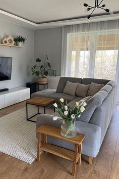 a living room filled with furniture and a flat screen tv on top of a wooden table