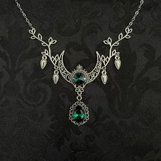 "This enchanting moon elf necklace features richly detailed antiqued silver tone filigree crescent, intricate leafy branches and elegant scroll drop accents. Its captivating design is adorned with dazzling emerald green glass crystals. Decorated portion is 4 1/2\" wide and 2 1/2\" tall in the very center.  Necklace length is adjustable with soldered stainless steel cable chain, lobster clasp and extender. If you would like a different length, please send us a message. Matching headpiece, pendant and earrings are listed separately in our store. If you don't see items with a color you want, feel free to ask about availability." Elf Necklace, Raw Carnelian, Moon Elf, Fantasy Necklace, Elven Jewelry, Carnelian Necklace, Filigree Necklaces, Choker Pendant, Crescent Moon Necklace