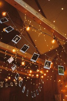 some lights hanging from the ceiling and pictures hung on strings with photos attached to them