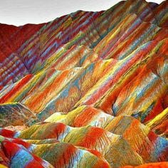 the colorful hills are painted with different colors and patterns, as well as some trees