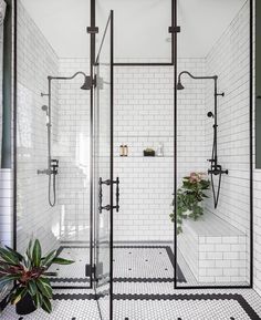 an image of a bathroom with black and white tile on the walls, shower head, and sink