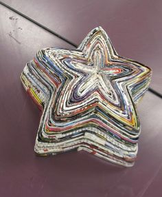 a multicolored star shaped object sitting on top of a purple surface