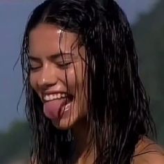 a close up of a person with wet hair and water on her face, smiling