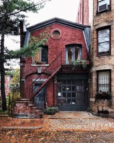 an old brick building with stairs leading up to the front door and second story windows