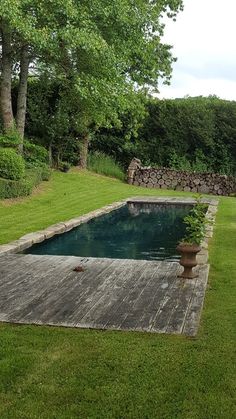 an empty pool surrounded by grass and trees