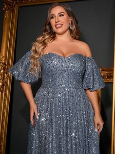 a woman standing in front of a mirror wearing a dress with sequins on it