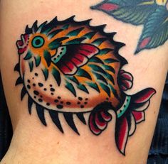 a colorful fish tattoo on the leg