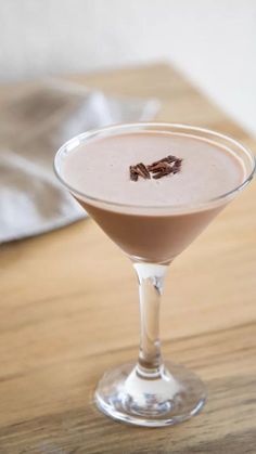 a drink in a martini glass on a wooden table