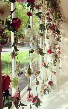 flowers hanging from the side of a window