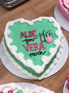 a heart - shaped cake with the words alde you vera much on it sits next to other decorated cakes